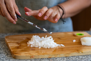 Cortando y picando vegetales y legumbres en casa sobre tabla de corte y cuchillo de cheff