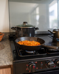 Cocinando cebolla y tomate en cocina casera