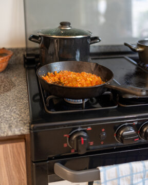 Cocinando cebolla y tomate en cocina casera