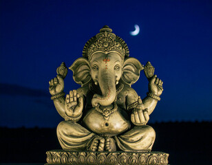 Fototapeta premium hindu god ganesha sculpture and a crescent moon afar in the background