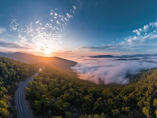 Fototapeta premium Sunrise over a mountain road, shrouded in mist