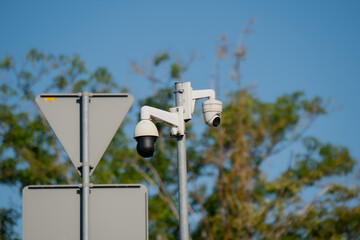 Modern surveillance security cameras monitoring urban traffic and public safety mounted on pole...