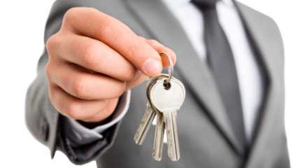 Businessman holding keys in a suit for property transaction