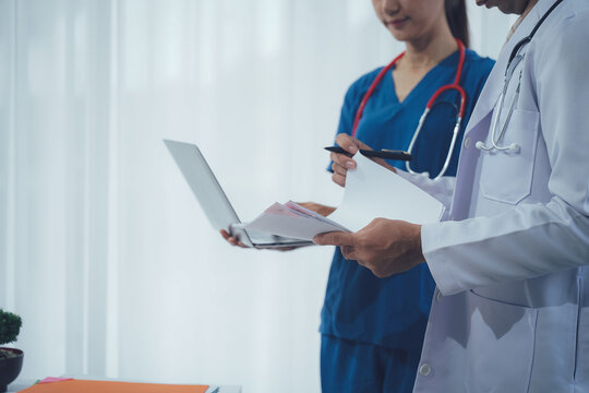 Medical Professionals Collaborate: A close-up shot of two medical professionals, a doctor and nurse, engrossed in collaborative discussion and assessment.