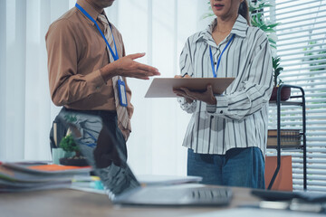 Office Collaboration: Two colleagues engaged in a focused discussion, their expressions...