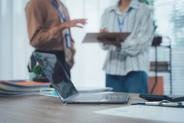 Obraz premium Office collaboration: two professionals engage in an office environment, with a focused view on a laptop in the foreground. capturing the collaborative essence of business.