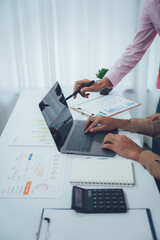Collaborative Analytical Meeting: Two individuals collaborate around a modern laptop, immersed in...