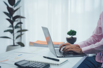 Professional's Focus: A professional diligently types on a sleek laptop at their well-organized workspace. The scene captures focused concentration and the tools of modern productivity.
