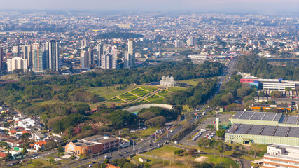 Obraz premium Expansive aerial view of Curitiba featuring Botanical Garden, high-rise buildings, and industrial zones.