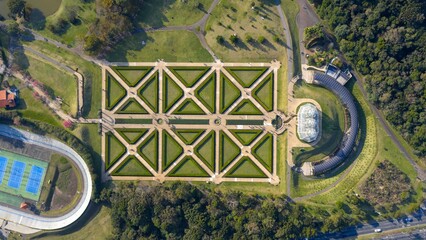 Top-down drone view of Curitiba Botanical Garden with symmetrical landscaping and greenhouse...