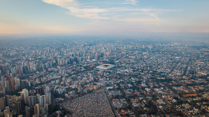 High-altitude aerial view of Curitiba cityscape at sunset, showing urban sprawl and skyline.