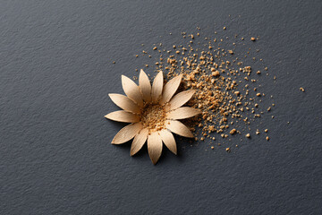 Golden Metallic Flower with Scattered Gold Powder on Dark Background