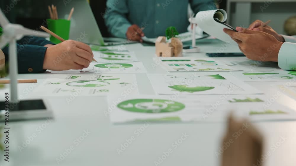 Poster a dynamic scene capturing business professionals engaged in analyzing green strategies using charts 