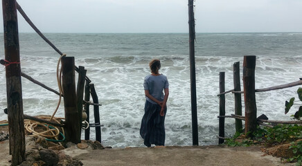 Back view silhouette of woman looking at ocean on the beach