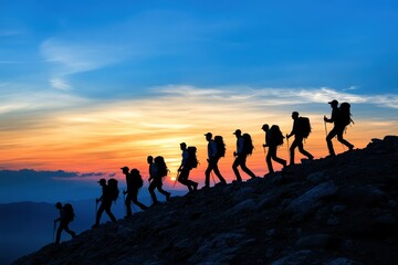Fototapeta premium A group of hikers ascends a mountain, silhouetted against a breathtaking sunset. The vibrant sky contrasts beautifully with the rugged terrain, showcasing adventure and camaraderie.
