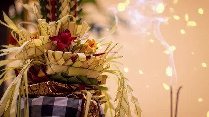 Balinese Piodalan celebration animation with warm orange to beige gradient, close-up of traditional canang sari offering with flowers and incense smoke