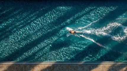 Overhead View of Swimming Pool with Lanes and Swimmer in Action
