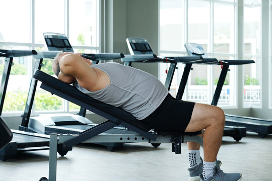 An overweight man exercises at the gym as part of his weight loss workout.