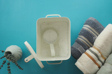 Laundry with fresh towels and detergent on blue
