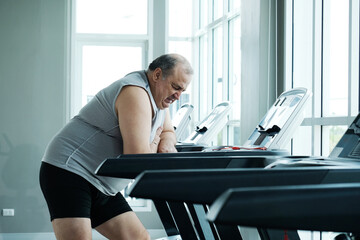 An overweight man is experiencing chest pain and tightness in his chest.