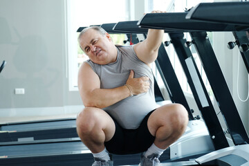 Obraz premium A man experiences chest pain or tightness while exercising at the gym.