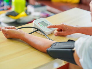 Close up arm people test blood pressure. Senior woman check high blood pressure at home concept...