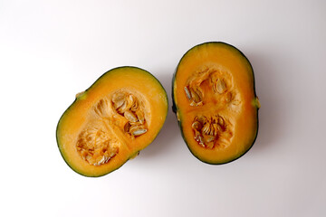 Fresh pumpkin cut in half on white background.