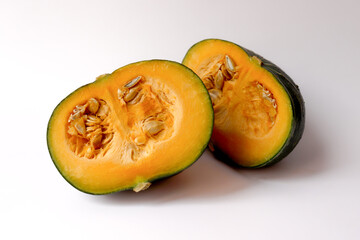 Fresh pumpkin cut in half on white background.