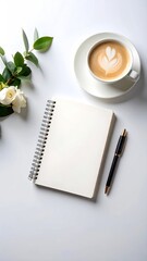 Blank notebook, coffee, and flowers on a white surface