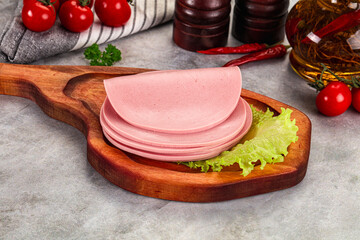 Sliced boiled sausage over board