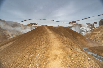 Blick auf einen Grat der den Blick in die Tiefe zieht, im Hintergrund schneebedeckte Berge in...