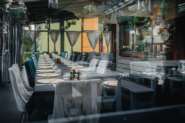 A hotel buffet. A garden banquet. Catering and waitstaff. A set table. Plates and glasses.