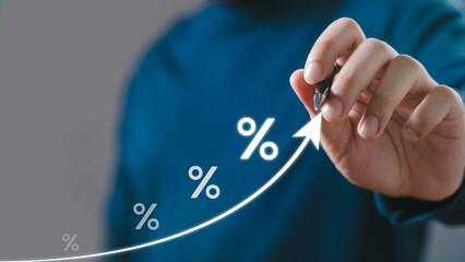 A person in a blue shirt is drawing a rising graph with percentages, symbolizing growth and...