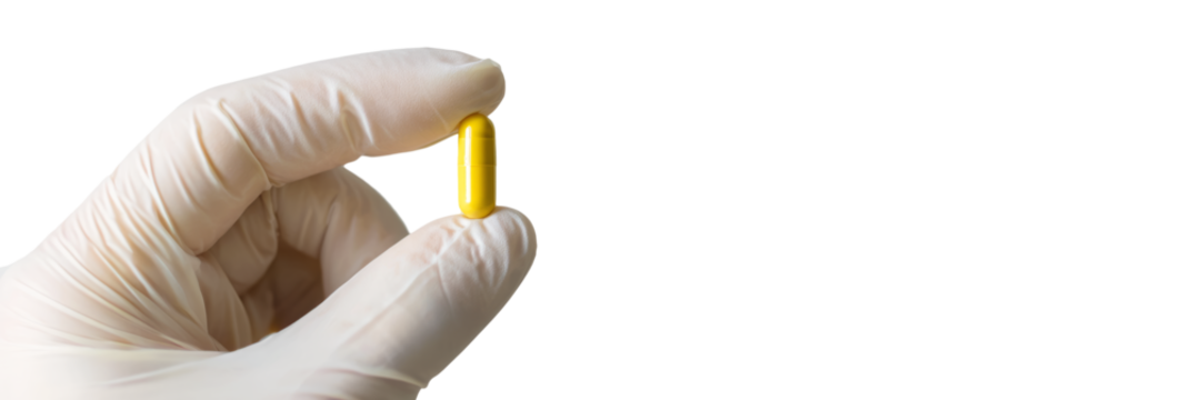 Latex-gloved fingers holding a capsule