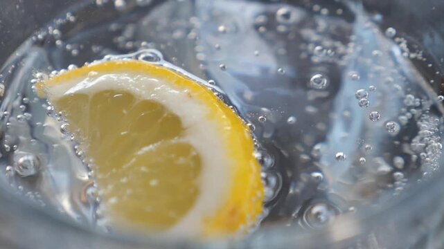 Refreshing drink with lemon slice in clear sparkling water