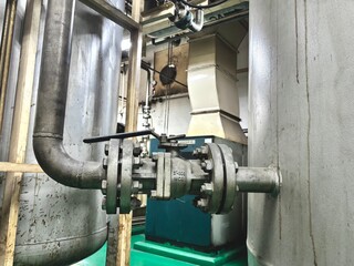 A large industrial valve with flanges connecting pipes in a power plant or factory. The robust...