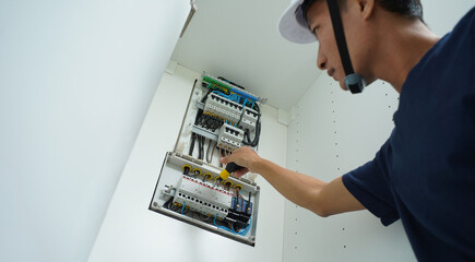 Electrician working checking a switchboard with fuses
