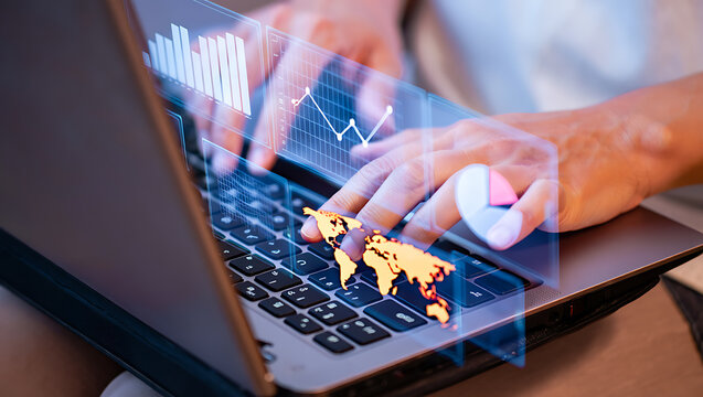 Hands typing on laptop with digital charts and world map image