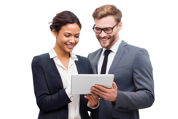 A man and woman in business attire standing together, smiling while looking at an iPad screen, isolated on a transparent background
