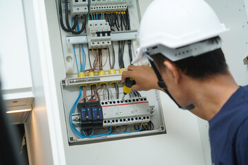 Electrician working checking a switchboard with fuses