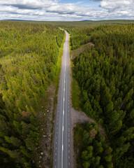 earial view, drone view of forest in Swedish Lapland. A straight asphals road is deviding the...