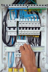Electrician working checking a switchboard with fuses
