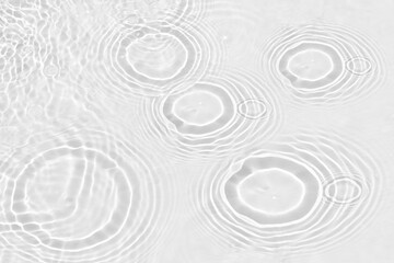 White water with ripples on the surface. Defocus blurred transparent white colored clear calm water surface texture with splashes and bubbles. Water waves with shining pattern texture background.