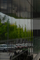 The reflection of a parking lot can be seen clearly in a large mirror, showcasing various elements...