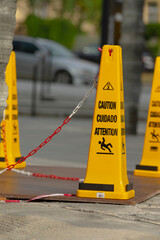 A bright yellow warning cone, prominently displaying the word caution on its surface, is placed...