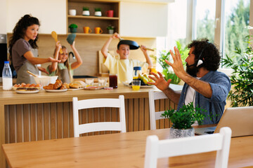 Father working from home having difficulty concentrating with noisy children