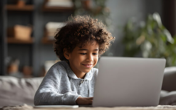 Smiling african american child school boy studying online on laptop at home
