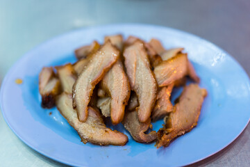 Thai grilled pork neck served on blue dish