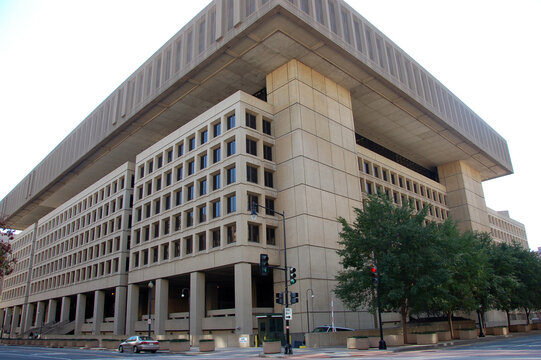Exterior view of the J. Edgar Hoover Building, the FBI headquarters in Washington, D.C., featuring its massive brutalist architecture and street corner