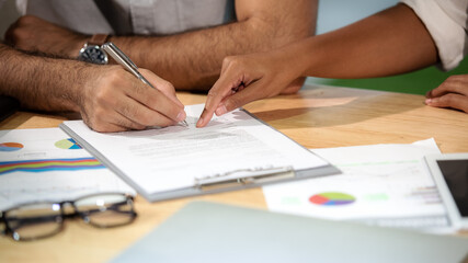 Man hand signing a contract on document for building house economic with architect and partner. select focus. Contract Concept